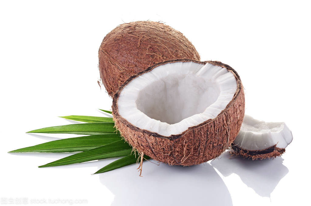 健康的食物。新鮮的椰子與綠色的棕櫚葉